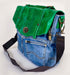 Stylish green leather and denim handbag with a unique design and adjustable strap.